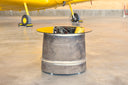Accent table made from tailpipe assembly of a convair aircraft. oval glass top. Burnished bronze patina with polished steel rings. 19.5" high